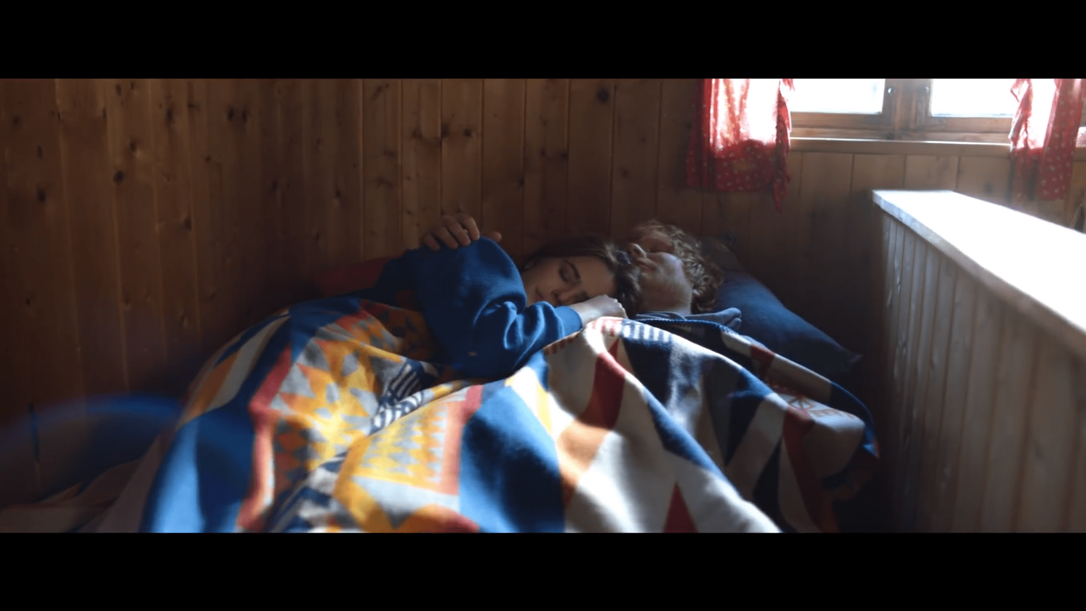 Screen shot from "Perfect" video by Ed Sheeran of a couple on a sofa in a cabin