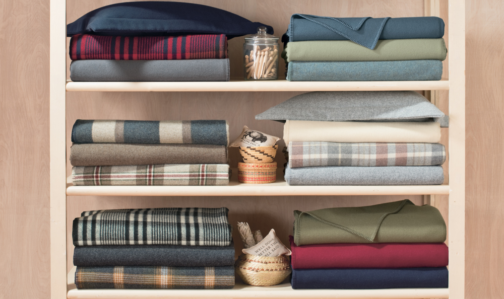 A shelf holding folded EcoWise Wool blankets by Pendleton