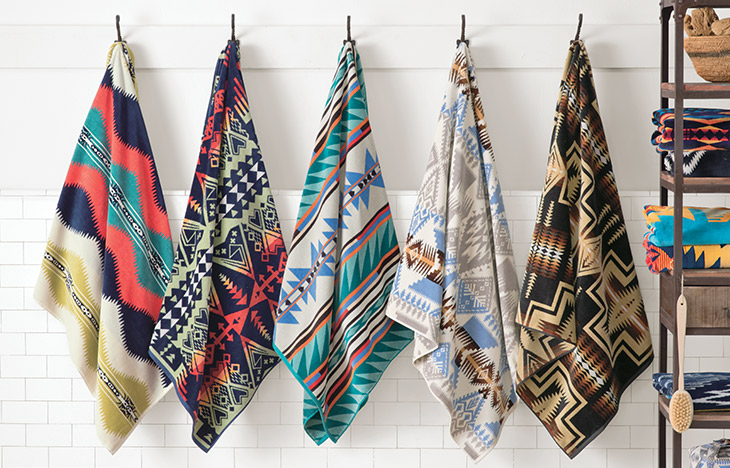 FIve Pendleton Towels hanging on a peg rack.