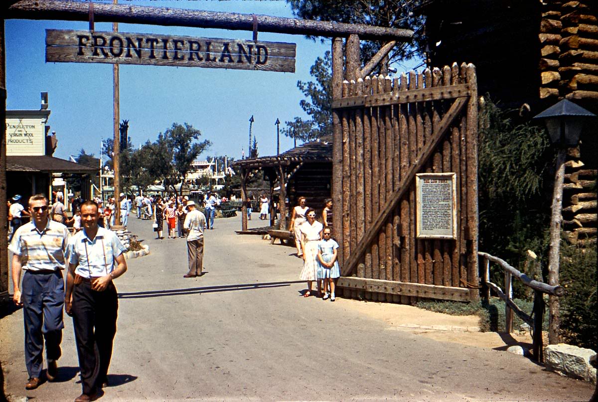 Happy guests at the wooden stockade gate to Frontierland in Disneyland, circa 1960