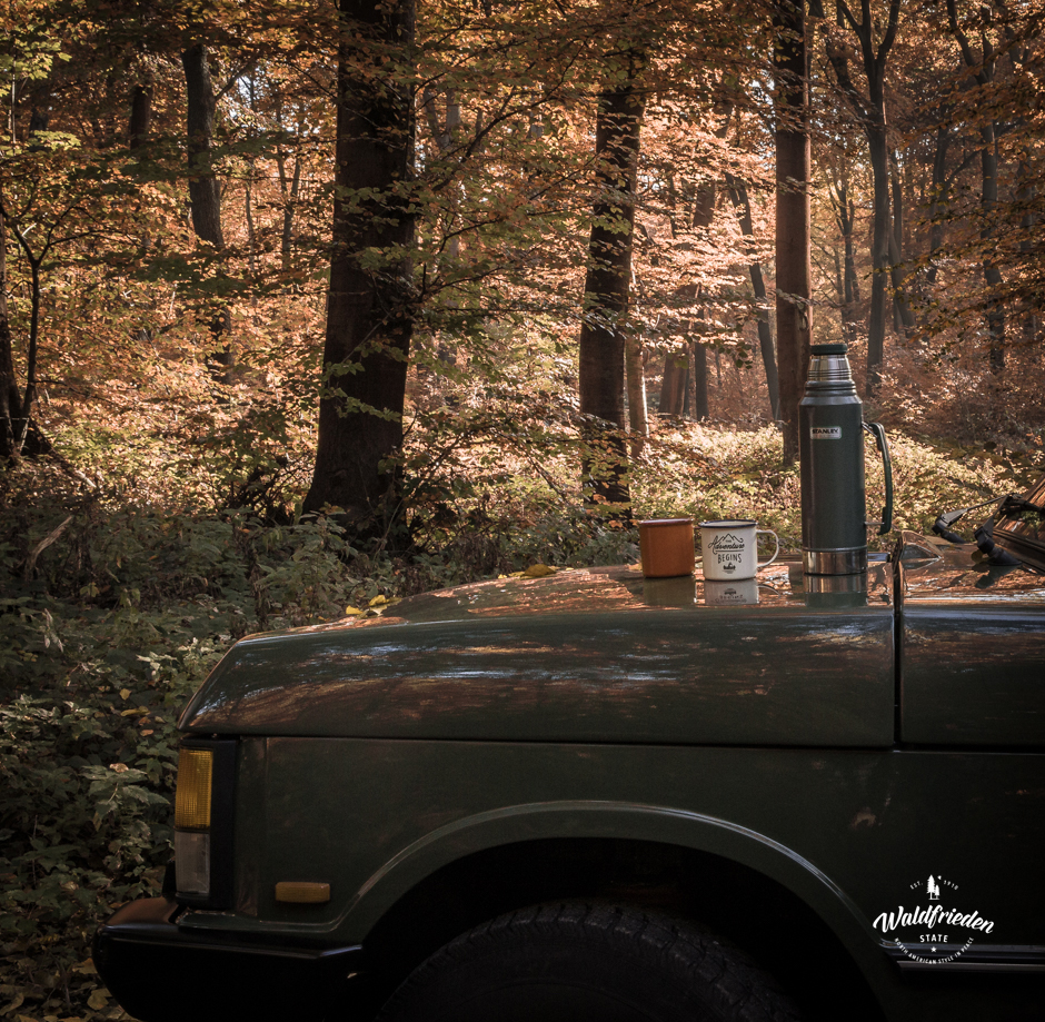 A vaccuum flask and coffee cups on the  hood of the Range Rover