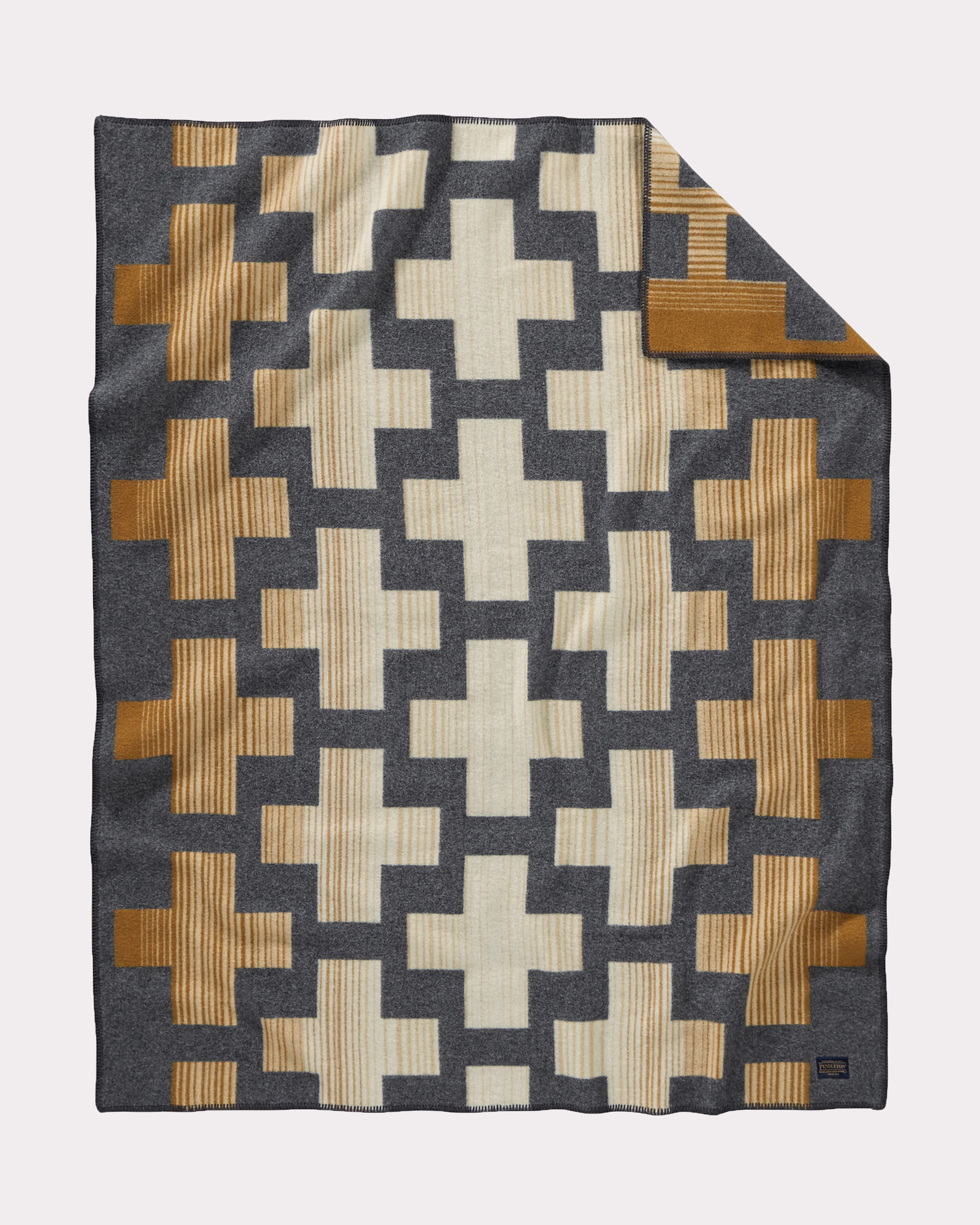 The Compass Point throw by pendleton is a geometric pattern of crosses in beige, cream and brown on a charcoal background.